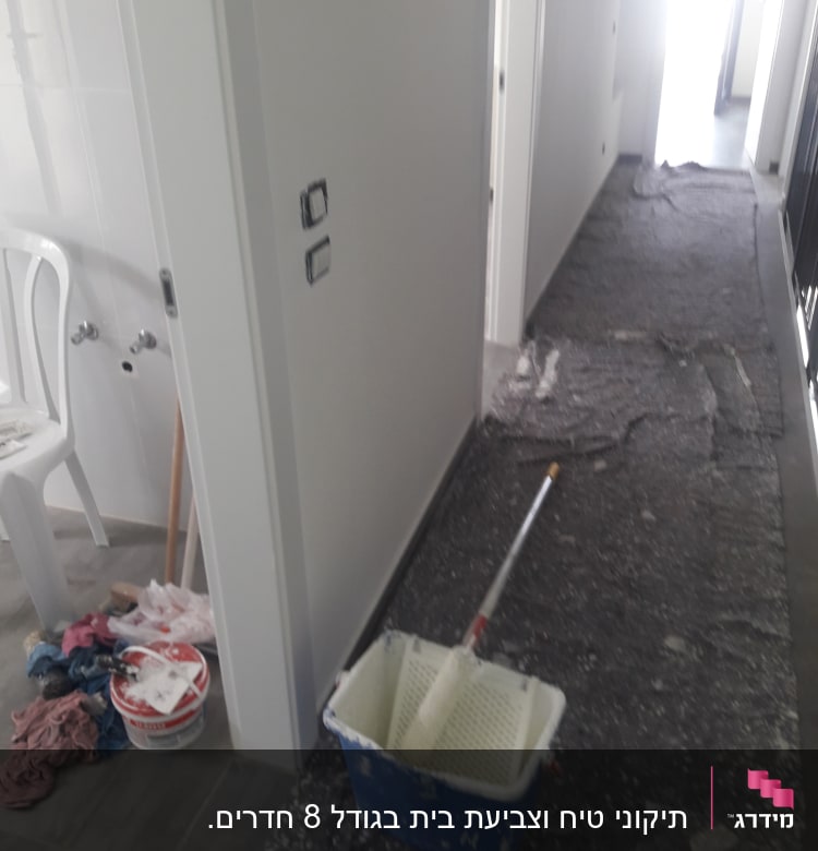 דלי צבע, רולר ומטליות על רצפה